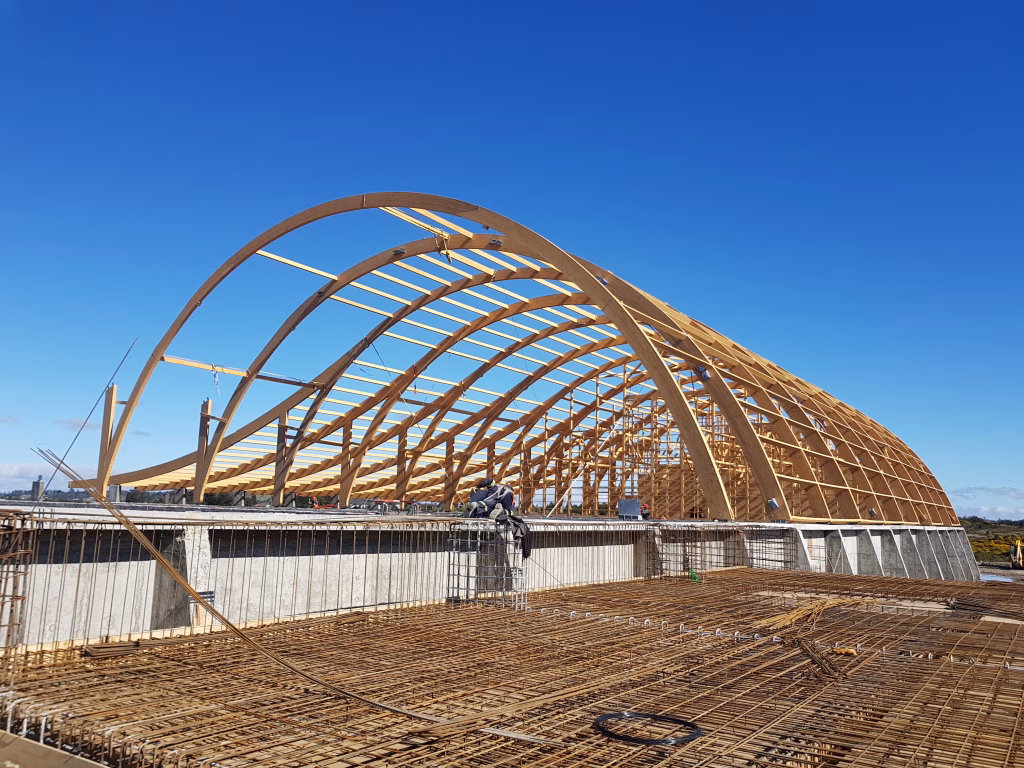 Fotografía de la estructura de madera laminada de las Bodegas SQM instalada sobre la losa de hormigón, mostrando el enrejado de acero y el avance de la construcción.
